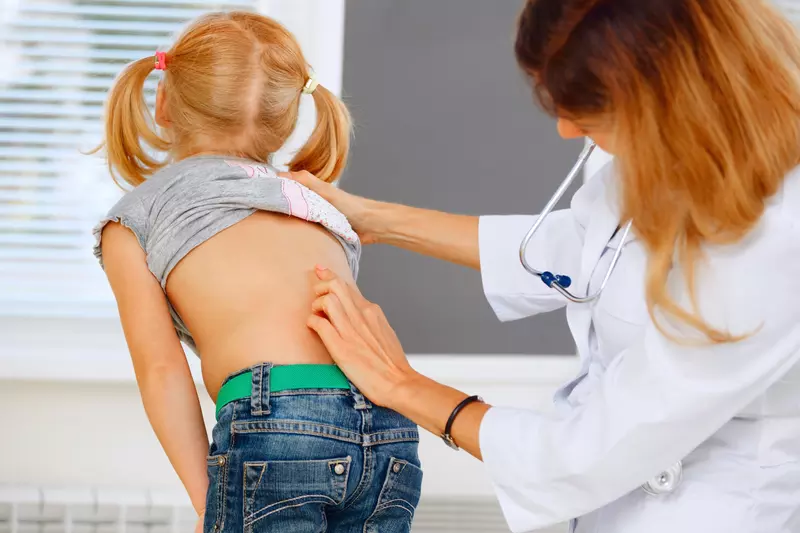 A child getting her spine examined.