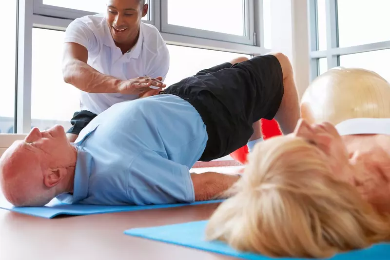 A couple does stretching and strengthening exercises with a physical therapist. 