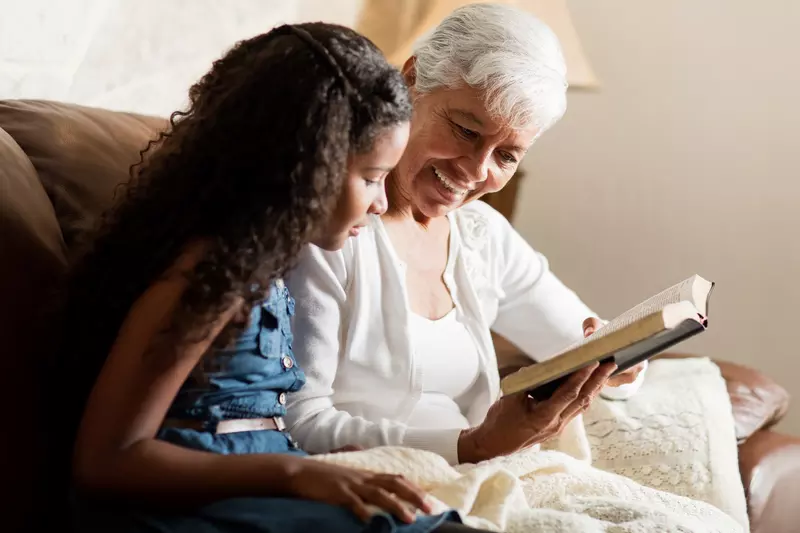 A grandmother and granddaughter read the Bible together.