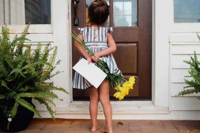 A little girl delivers flowers to a loved one's front door.