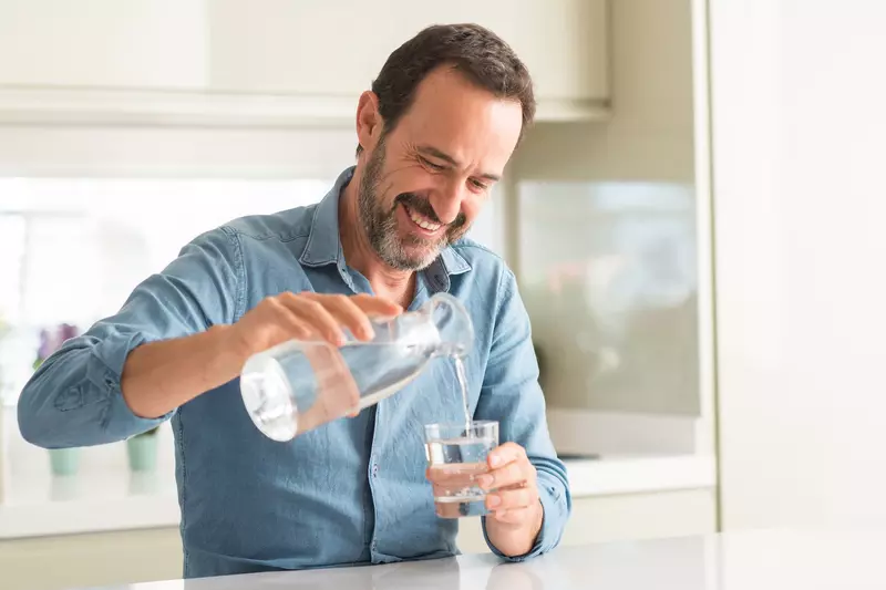 A man pouring a glass of water.