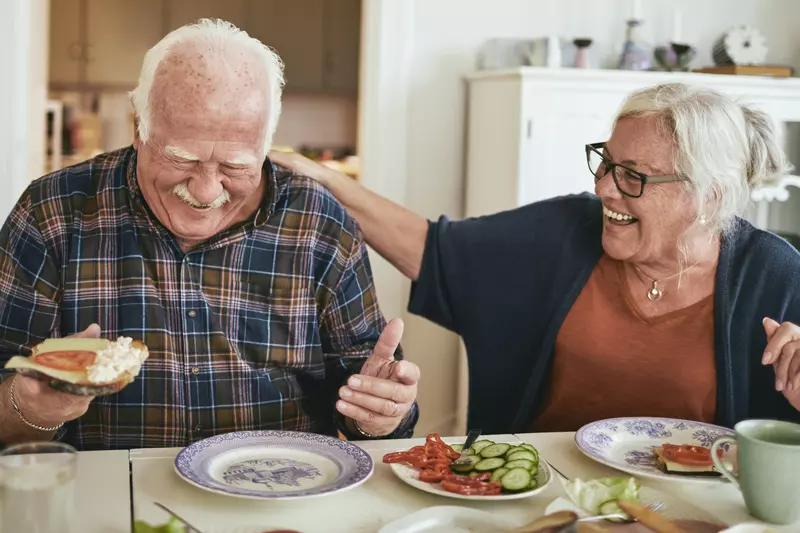 A couple enjoys a meal while laughing about their day.