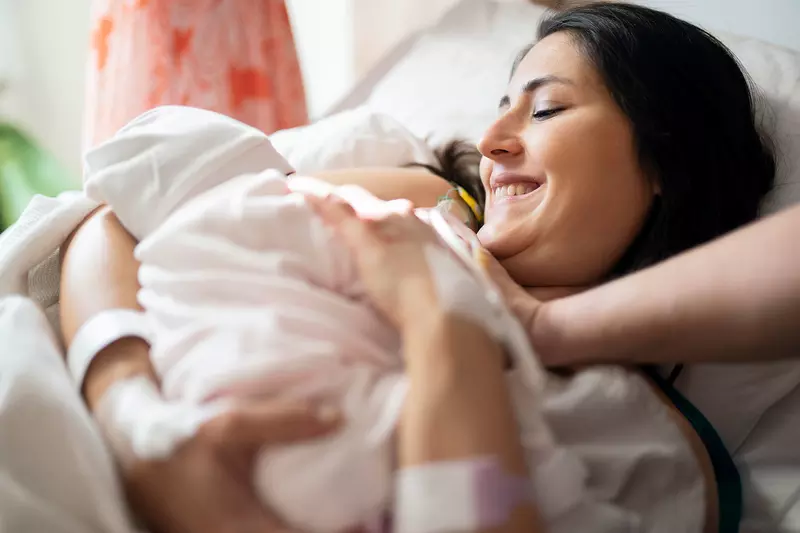 A new mom holds her infant after delivery. 