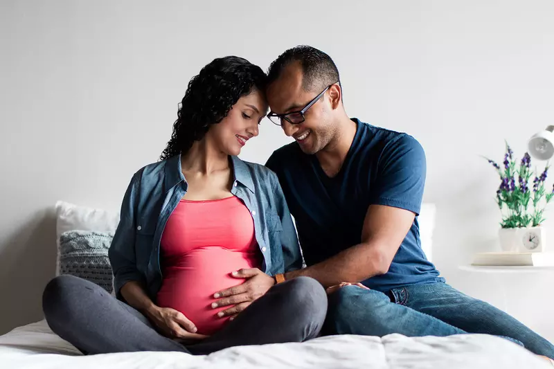 A pregnant couple at home.