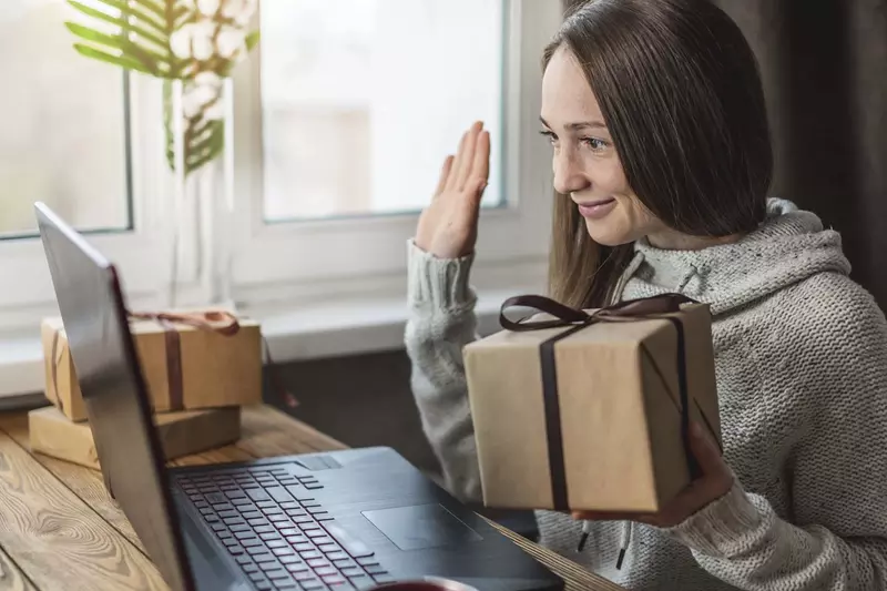 A woman doing a gift exchange on a video call.