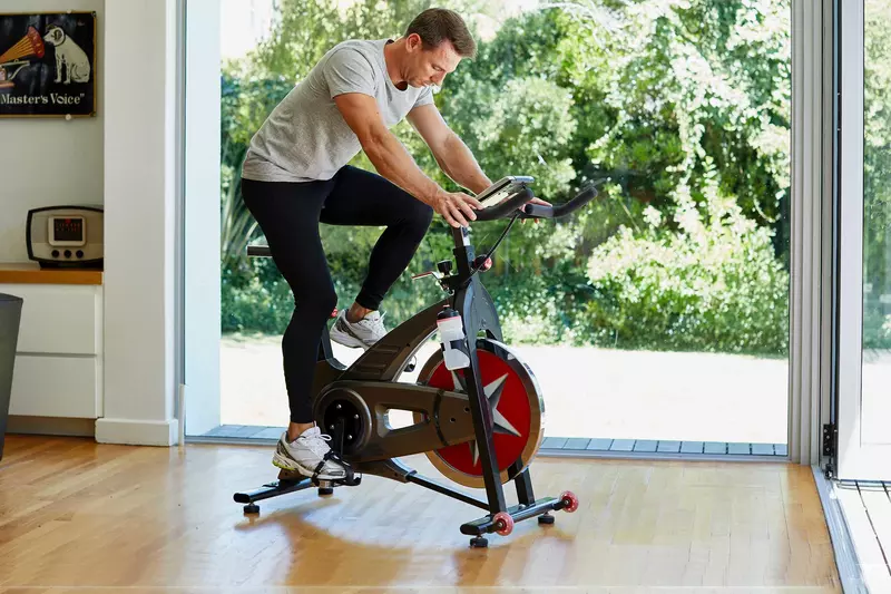 A man riding an exercise bike at home.