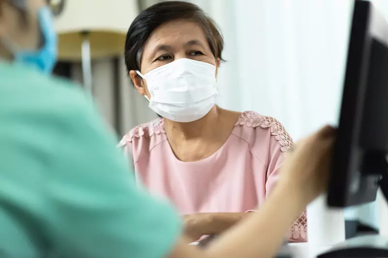 A woman at a doctor's appointment wearing a mask.