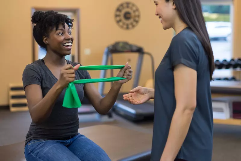 A woman does strengthening exercises with her physical therapist.
