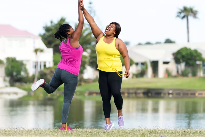 Two women high-five after a great workout outside.