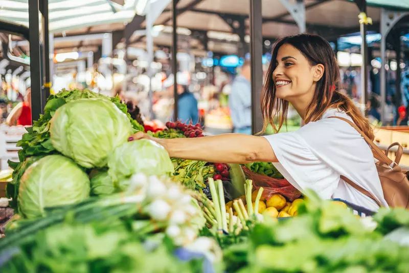 Young woman explores the farmers market for the best produce