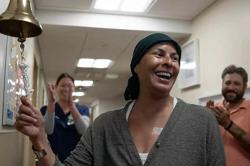 Smiling patient ringing a bell