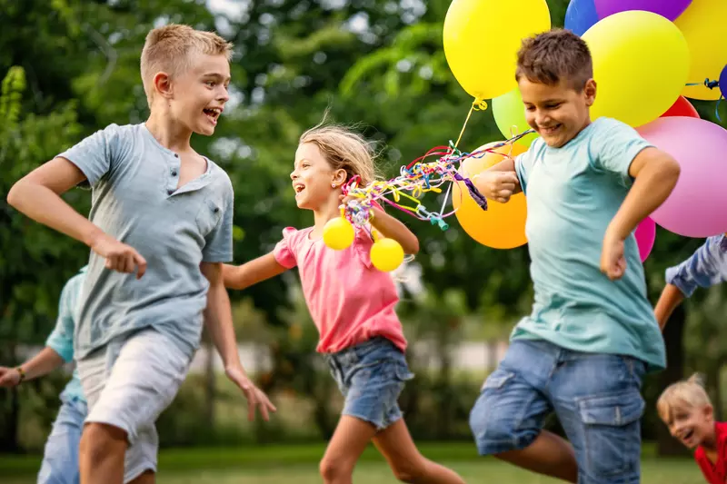 Kids running and playing with balloons
