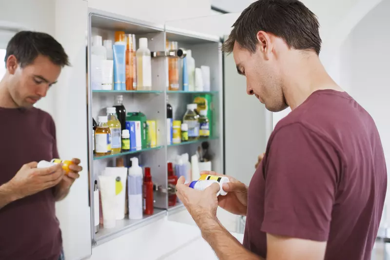 Man cleaning medicine cabinet