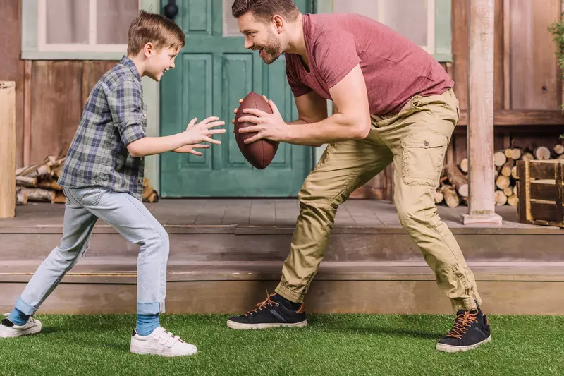 Father and son playing a backyard game of football.