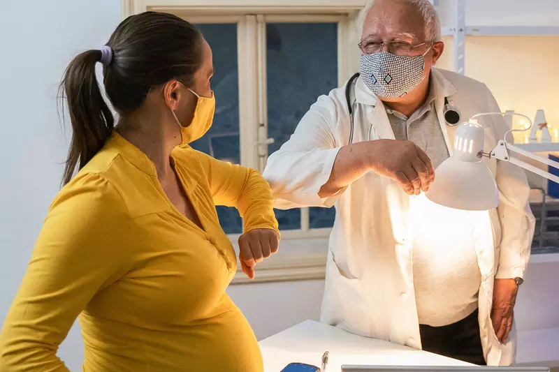 A pregnant woman visiting her doctor for her flu shot.