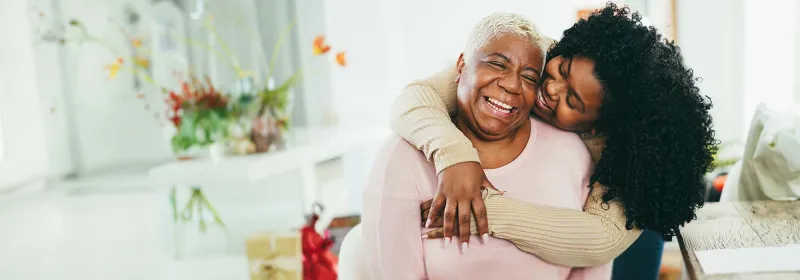 Seated mother embraced by daughter