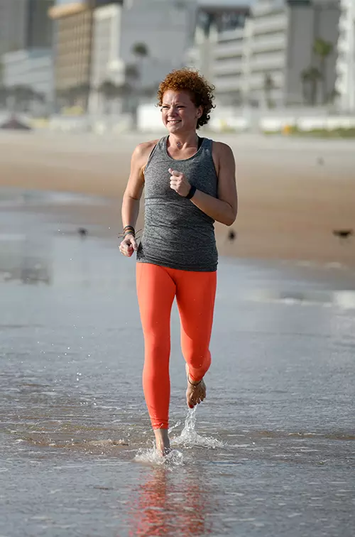 Chelsea, an AdventHealth Bariatrics patient, runs on the beach.