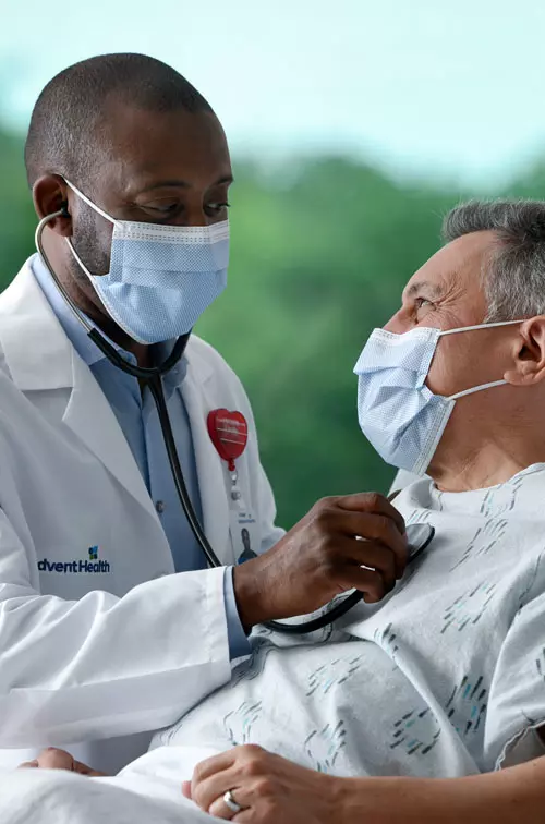 Masked doctor with masked patient in Emergency Room