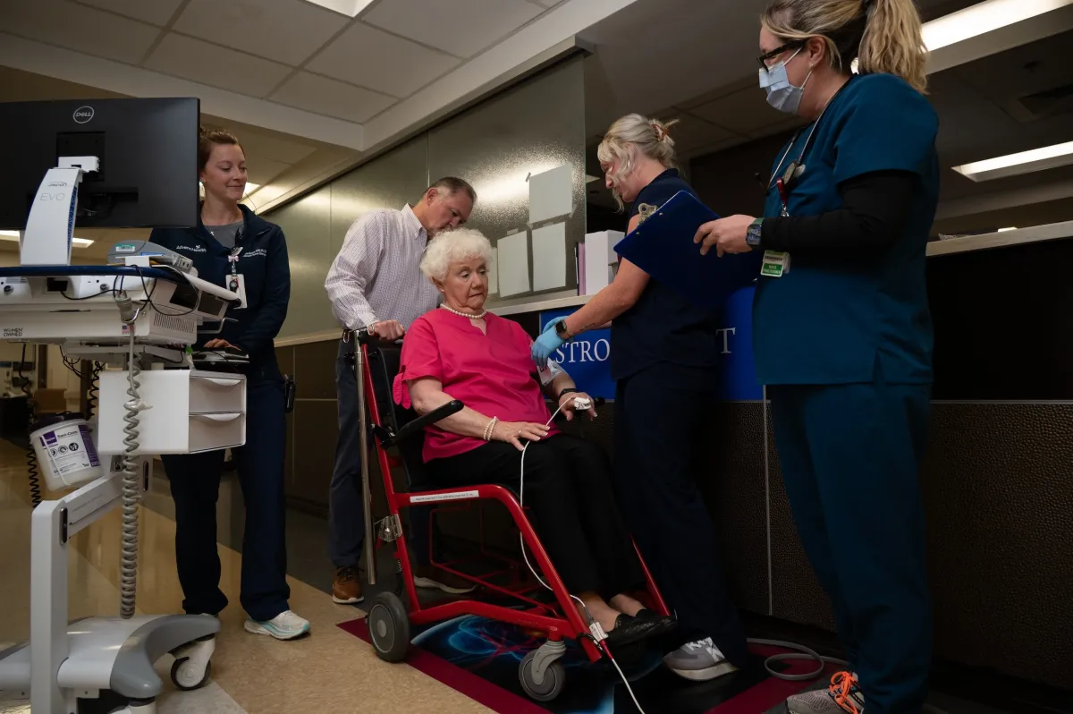 Members of the AdventHealth Redmond stroke team attend a patient in a wheelchair who appears to be experiencing symptoms of a stroke.