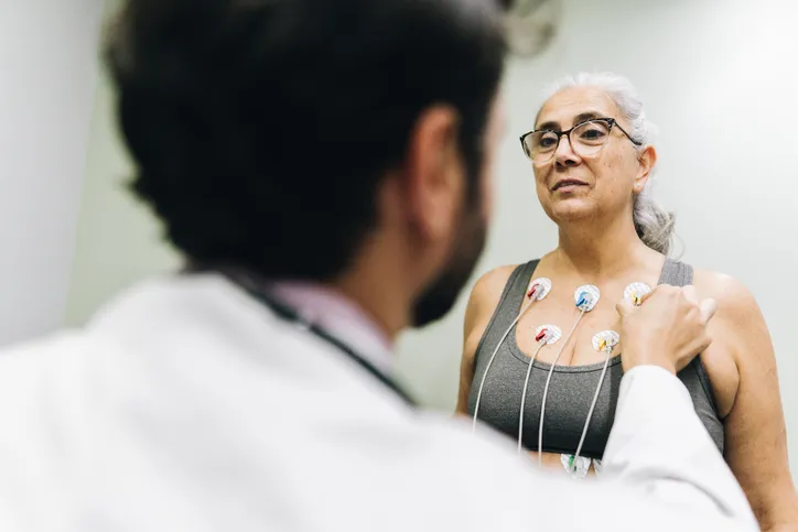 Patient talking with her doctor during a cardiopulmonary stress test on a hospital - stock photo
