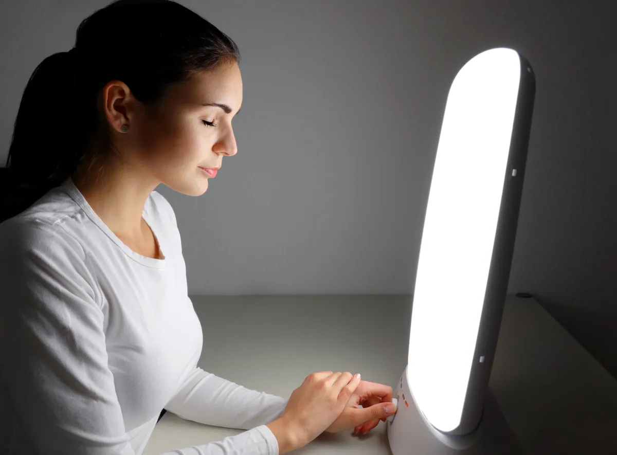 Woman sitting in front of a daylight lamp to combat winter depression