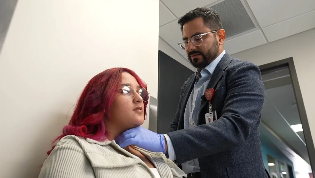 Dr. Joseph Lopez examines the neck of one of his female patients, Zoe, who had a cancerous tumor.