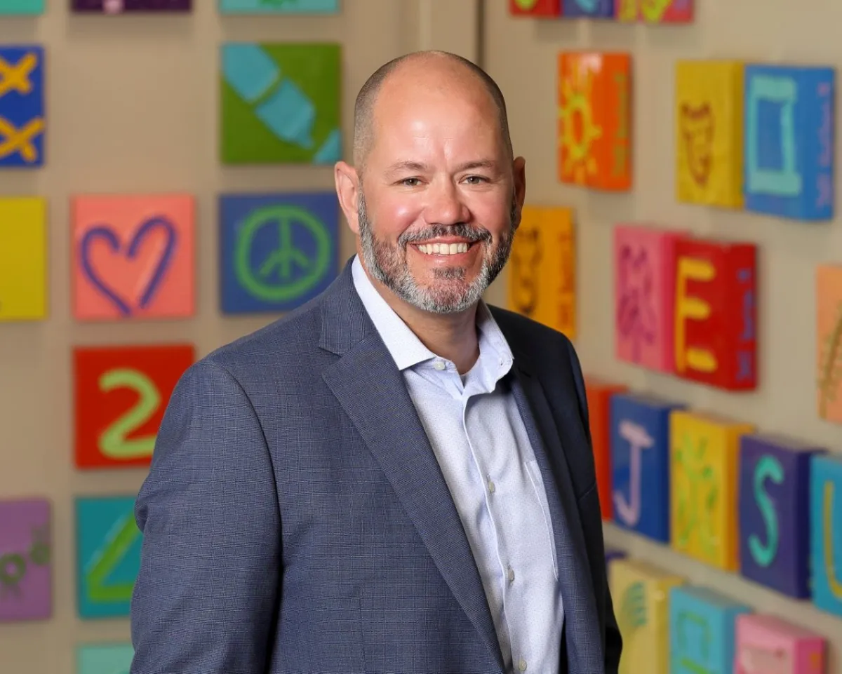 Man in front of colorful background. 