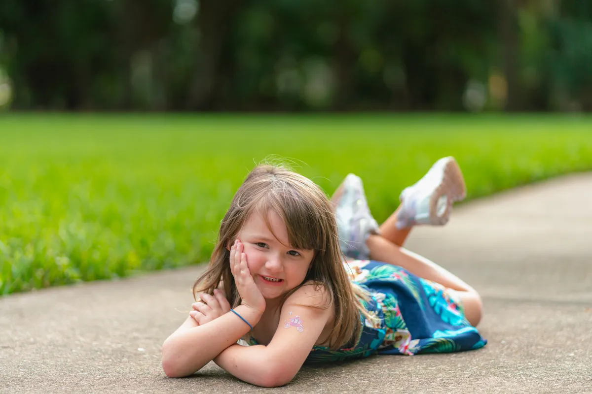 A young girl laying down at a park