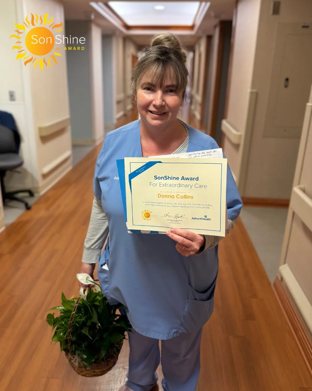 Donna Collins, a white woman in light blue scrubs, smiles holding her SonShine Award certificate.
