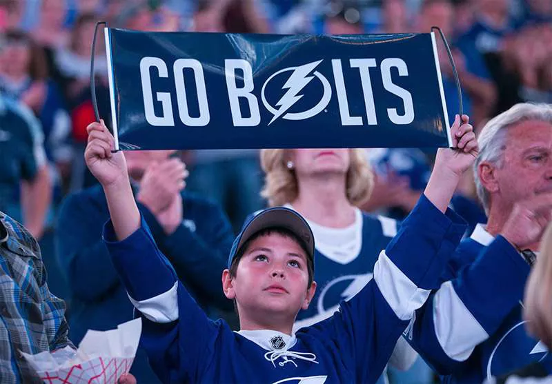 Young Tampa Bay Lightning fan holding a "Go Bolts" sign.