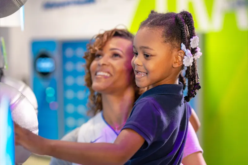 A Woman Hold Her Daughter in the Gift Shop of The Amway Center
