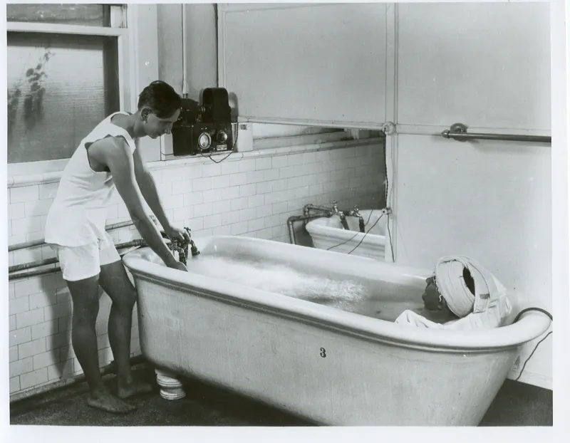 Man with a patient in a hydrotherapy tub.