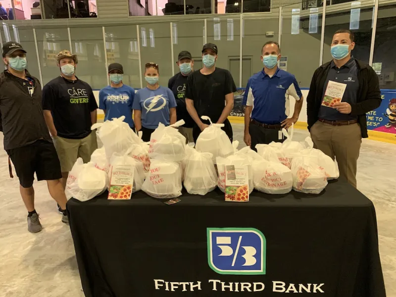 A group of people standing at a table with food donations