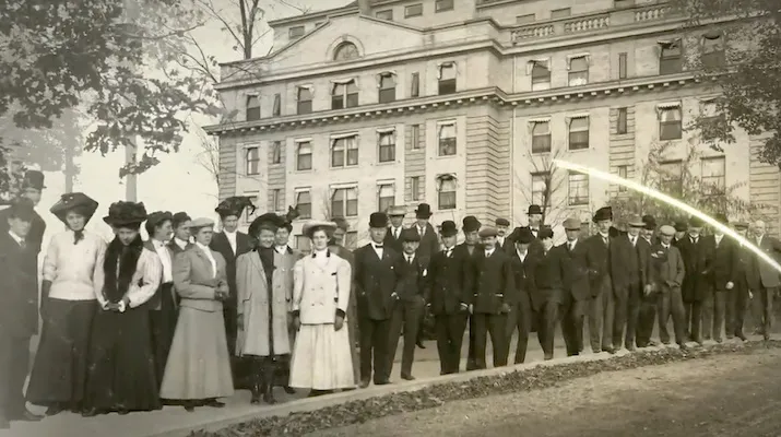 Black and white historical photo of people standing in front of a Sanitarium