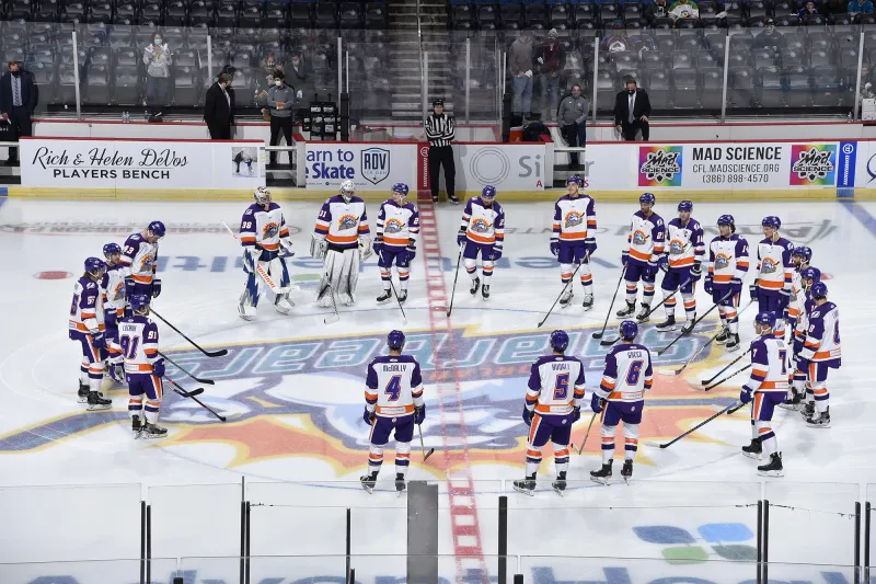 Orlando Solar Bears players standing in a circle formation on the ice.