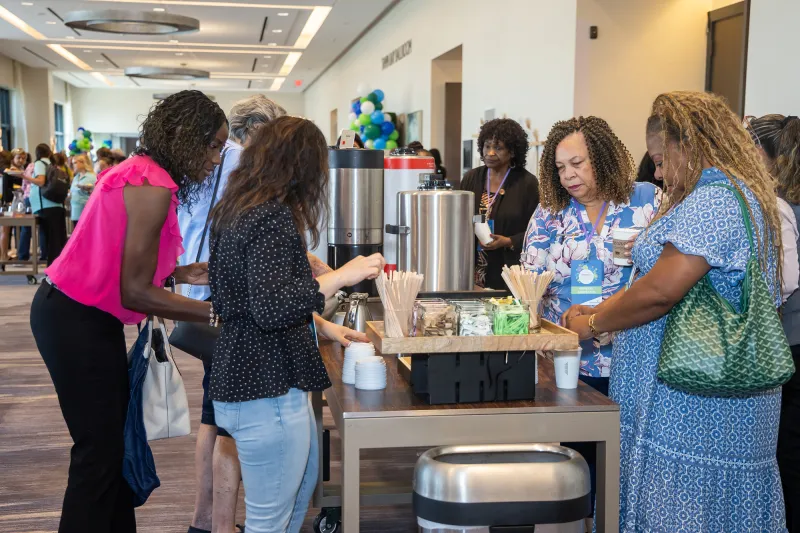 Women attending the Women’s Health and Cancer Prevention Event, near the snack table.