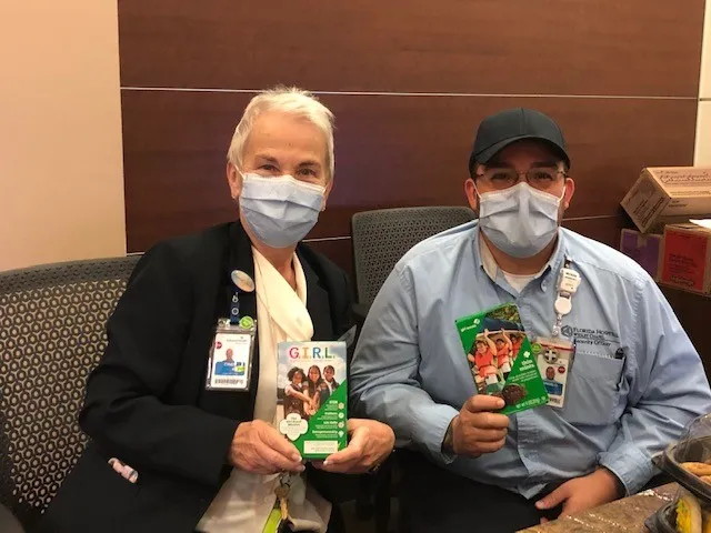 Medical professionals holding boxes of girl scout cookies