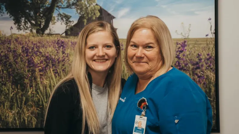 ottawa two nurses standing in front of flower picture