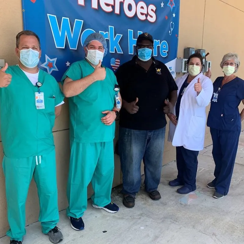 Physicians wearing masks give thumbs up