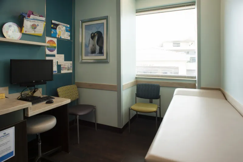 Room furnished with bed, chairs, and desks